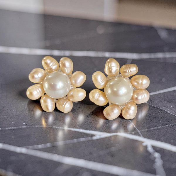 Daisy stud earrings made with pink freshwater rice pearls and mother of pearl, set on sterling silver studs, handmade floral jewellery.