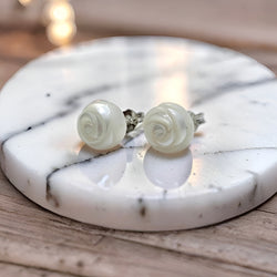 Hand-carved freshwater pearl earrings with rose-like spiral design set on sterling silver studs