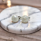 Hand-carved freshwater pearl earrings with rose-like spiral design set on sterling silver studs