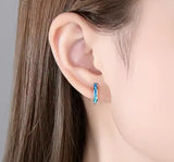 Sterling silver blue opal huggie earrings with shimmering October birthstone
