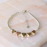 Swarovski crystal spike bracelet with sterling silver beads and adjustable chain clasp on neutral stone background