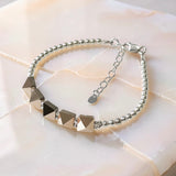 Swarovski crystal spike bracelet with sterling silver beads and adjustable chain clasp on neutral stone background
