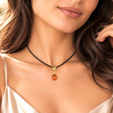 Swarovski orange teardrop crystal pendant with sterling silver bail on a black cord necklace, model wearing the necklace.
