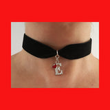 Black velvet ribbon choker necklace with a sterling silver letter and a red enamel heart pendant.